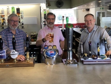Rugby MP Mark Pawsey (centre) pulls a pint with David Hine, Fighting Cocks publican (left) and Julian Searle, , Regional Manager for the EI Group (right)
